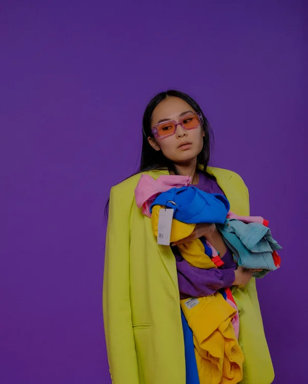 Model in a statement outfit on a purple background
